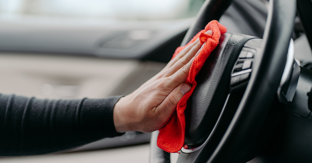 prepare your car for a shoot by cleaning it - hand wiping down sterring wheel