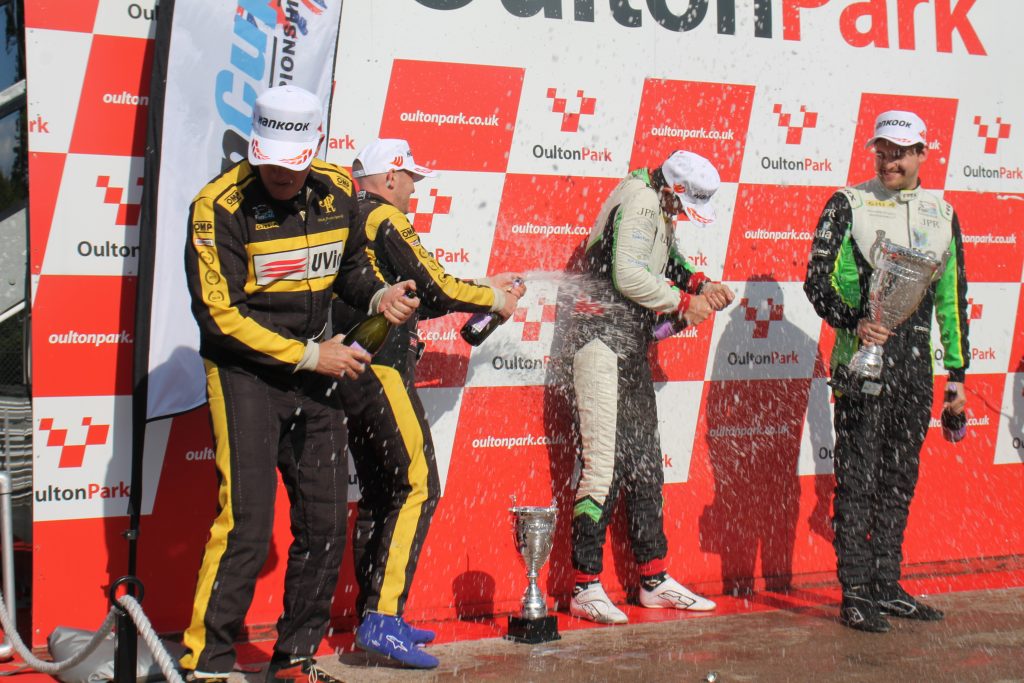 Race team celebrating in the paddock after a motorsport event